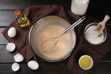 Photo of Flat lay composition with whisk and dough in bowl on wooden table