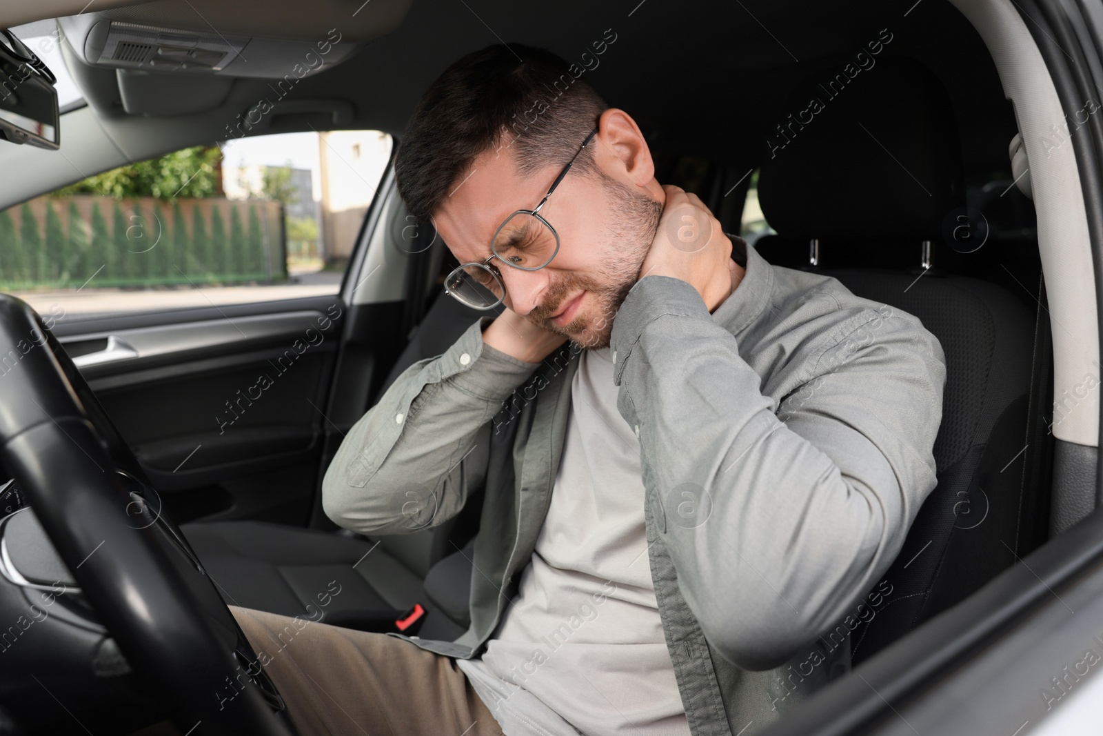 Photo of Man suffering from neck pain in car