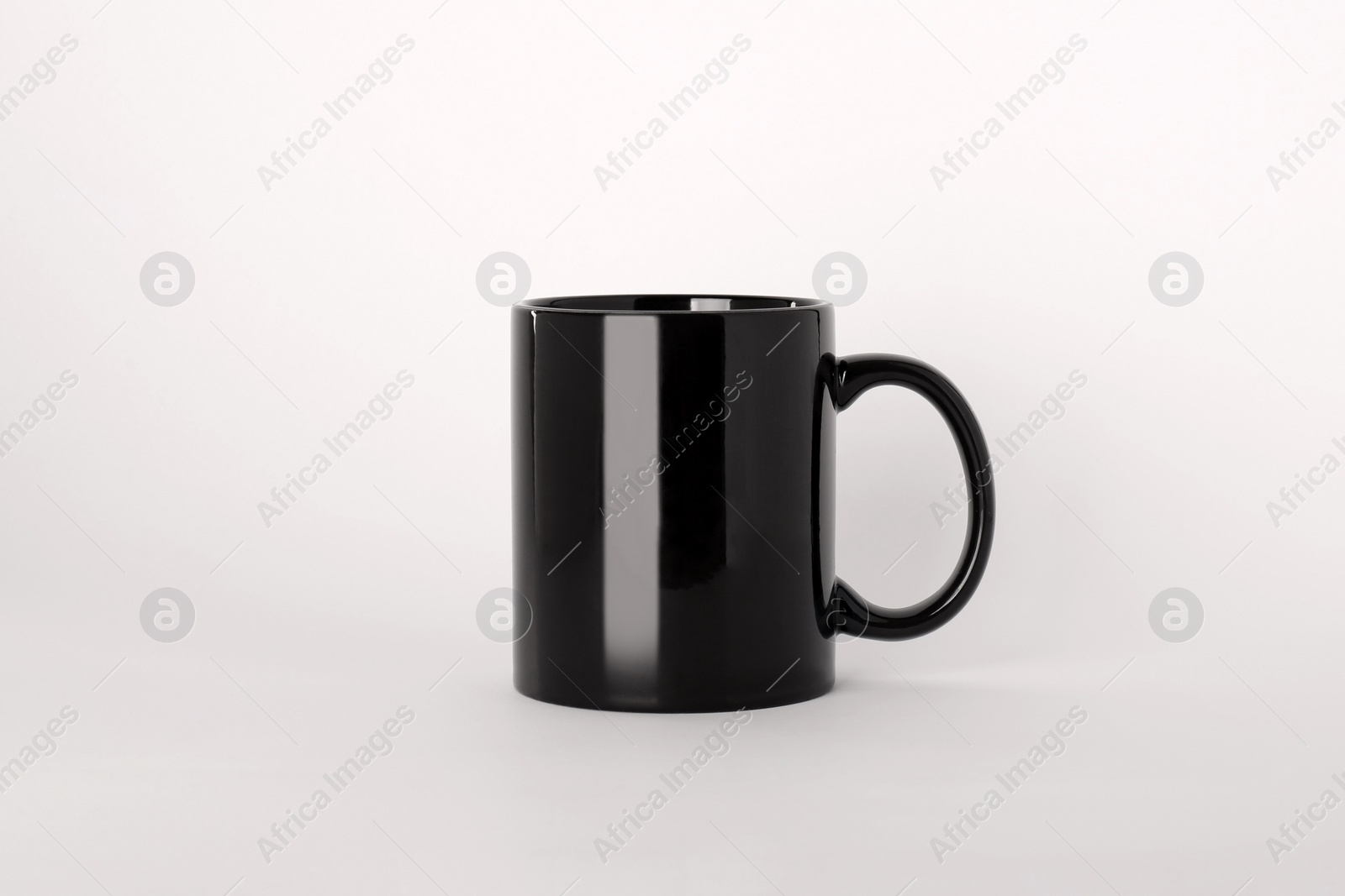 Blank black ceramic mug on light background Photo of Blank black ceramic mug on light background