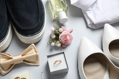 Photo of Wedding stuff. Composition with stylish boutonniere on light gray background, above view