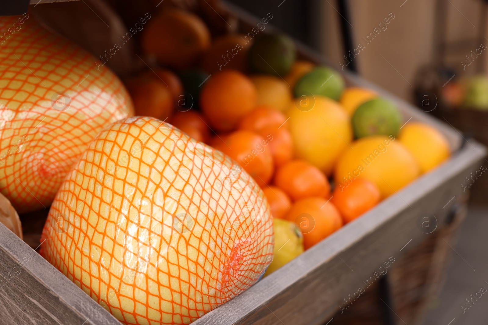 Photo of Fresh ripe fruits in wooden crate at market, closeup. Space for text