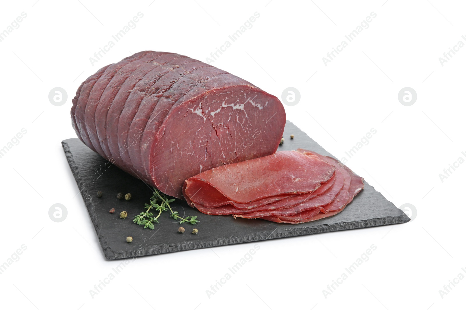 Photo of Tasty fresh dry bresaola, peppercorns and thyme isolated on white