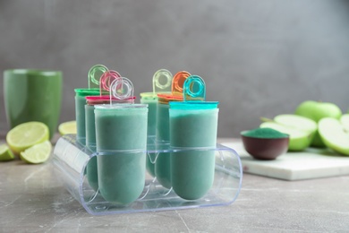 Delicious spirulina popsicles in ice cream mold on table
