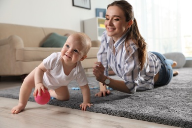 Photo of Adorable little baby crawling near mother at home