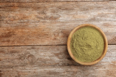 Bowl with hemp protein powder on wooden table, top view. Space for text