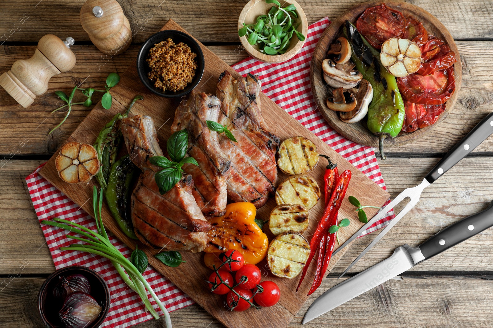 Photo of Delicious grilled meat and vegetables served on wooden table, flat lay