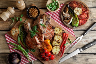 Photo of Delicious grilled meat and vegetables served on wooden table, flat lay