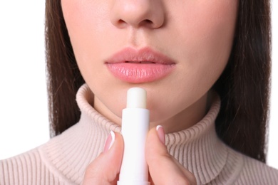 Photo of Young woman applying cold sore balm on lips, closeup