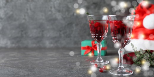 Image of Delicious Christmas cocktail with liqueur on grey table, space for text. Banner design