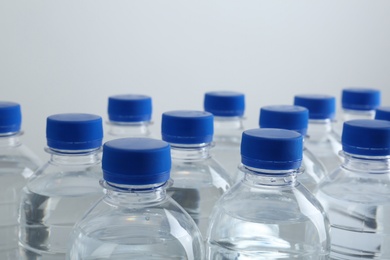 Rows of plastic bottles with pure water on white background