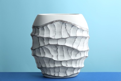 Photo of Stylish empty ceramic vase on table against light blue background
