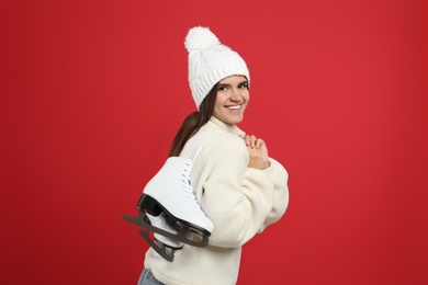 Photo of Happy woman with ice skates on red background