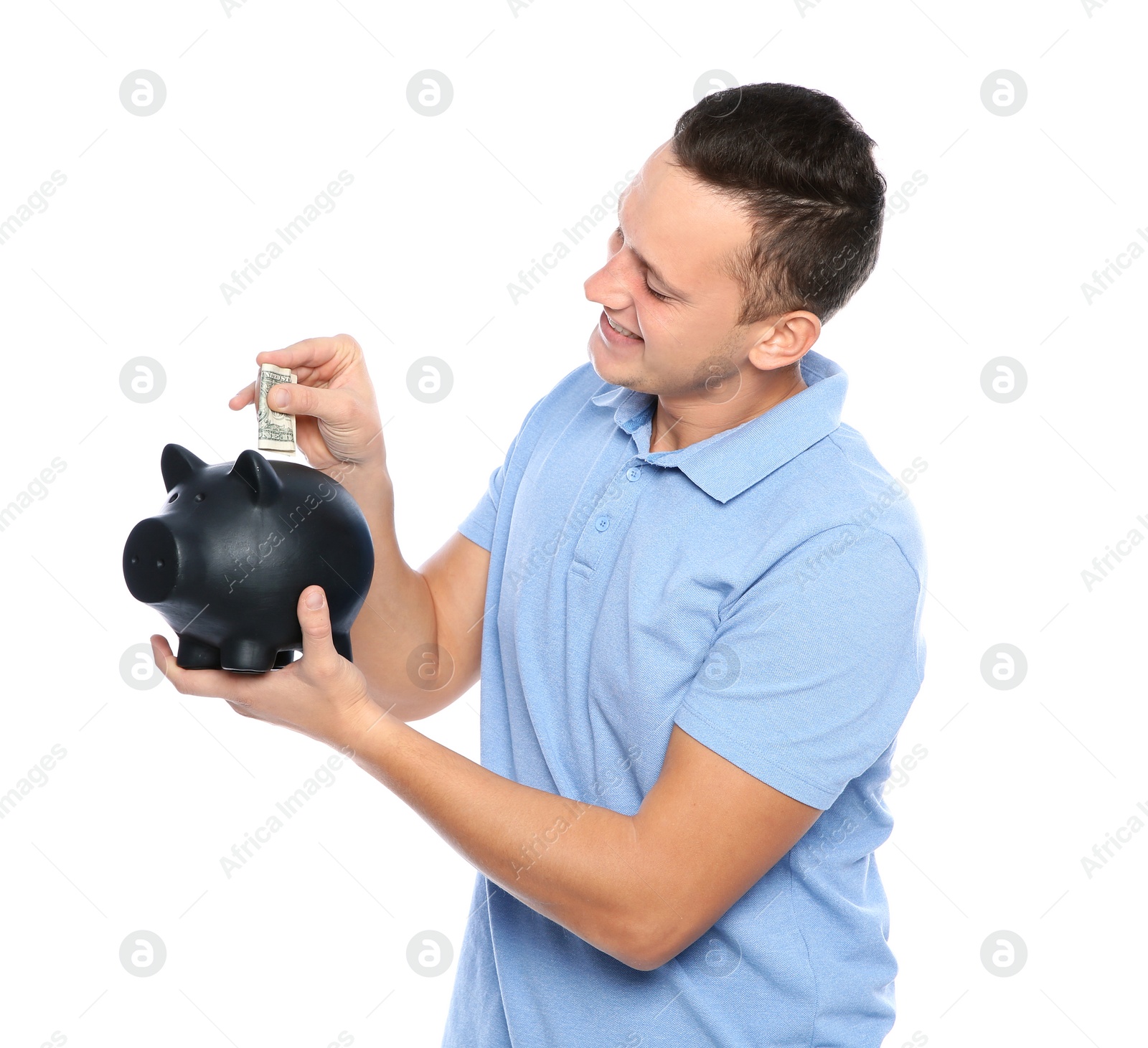 Photo of Young man putting money into piggy bank on white background