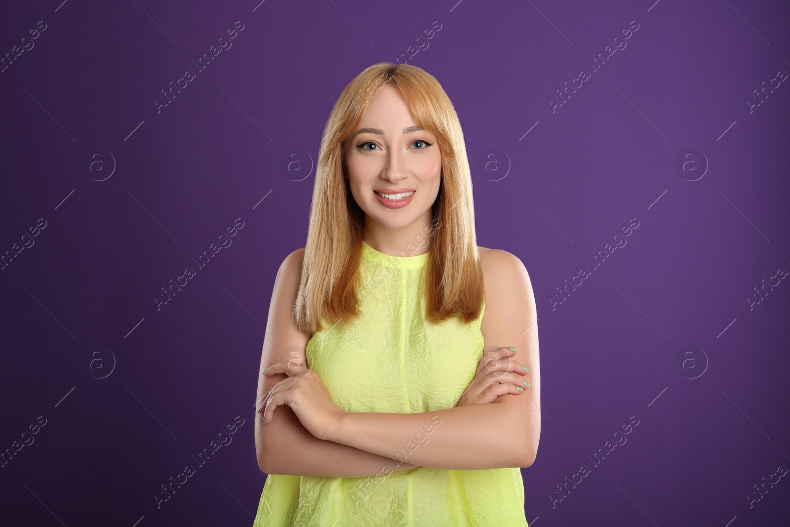 Photo of Beautiful young woman with blonde hair on purple background