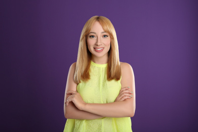 Photo of Beautiful young woman with blonde hair on purple background