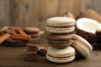 Delicious macarons and chocolate on wooden table