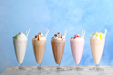 Photo of Glasses with delicious milk shakes on table