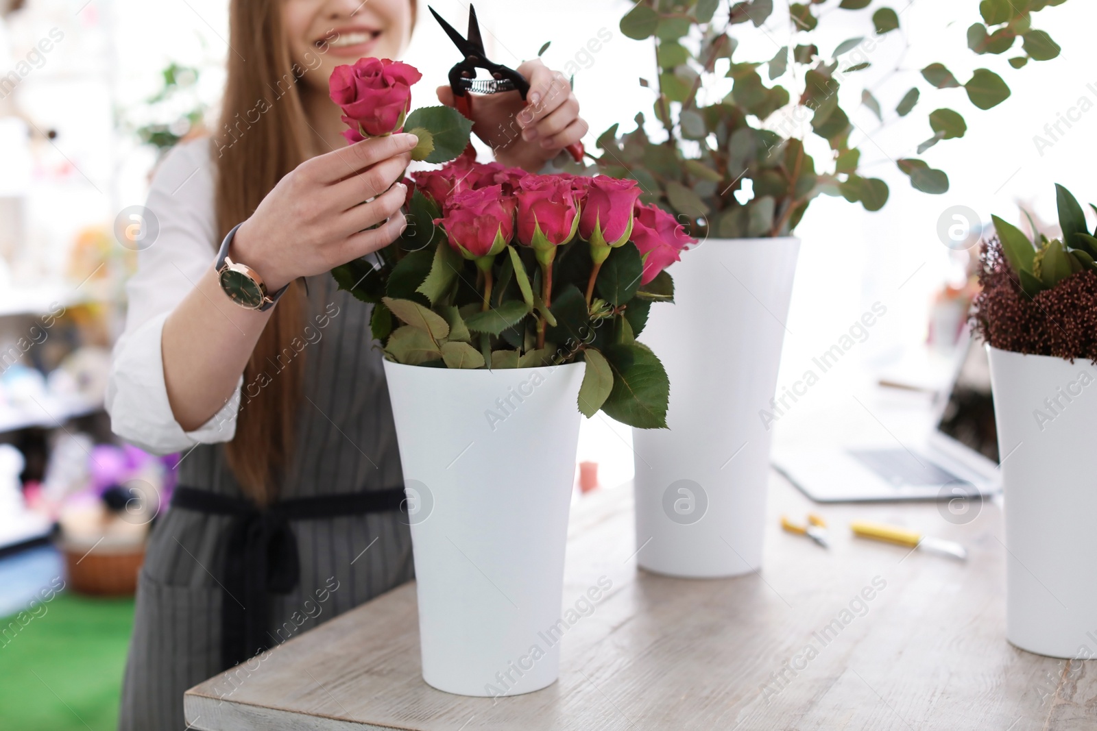 Photo of Female florist making beautiful bouquet in flower shop, closeup