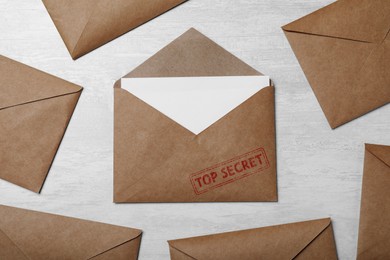 Image of Top Secret stamp. Paper envelopes on light grey table, flat lay