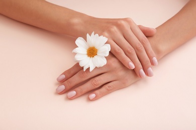 Closeup view of woman with flower on color background. Spa treatment