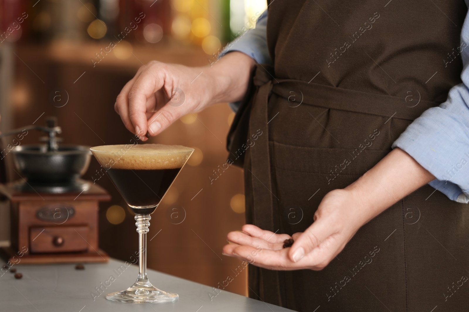 Photo of Woman preparing Espresso Martini on bar counter, closeup. Alcohol cocktail