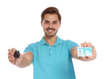 Happy young man with driving license and car key on white background