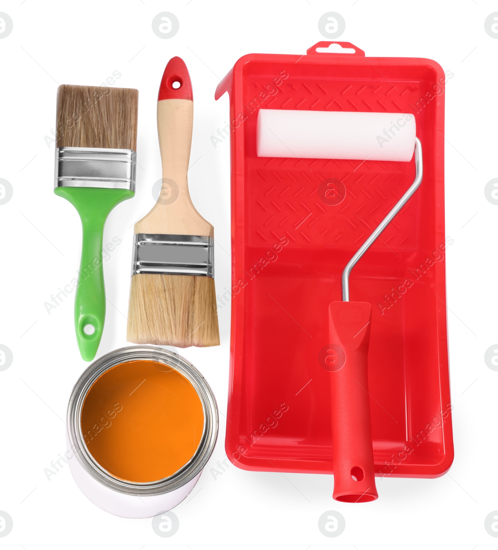 Photo of Can of orange paint, roller, container and brushes on white background, top view