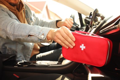 Photo of Man with first aid kit inside car, closeup