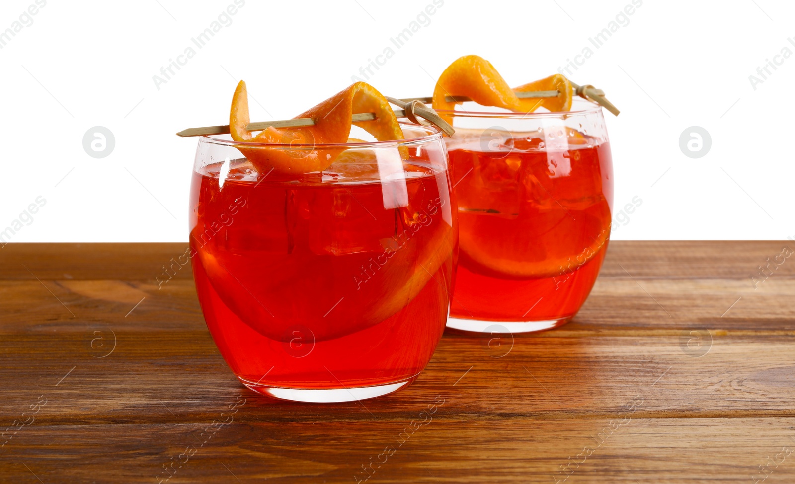 Photo of Aperol spritz cocktail and orange slices in glasses on wooden table against white background