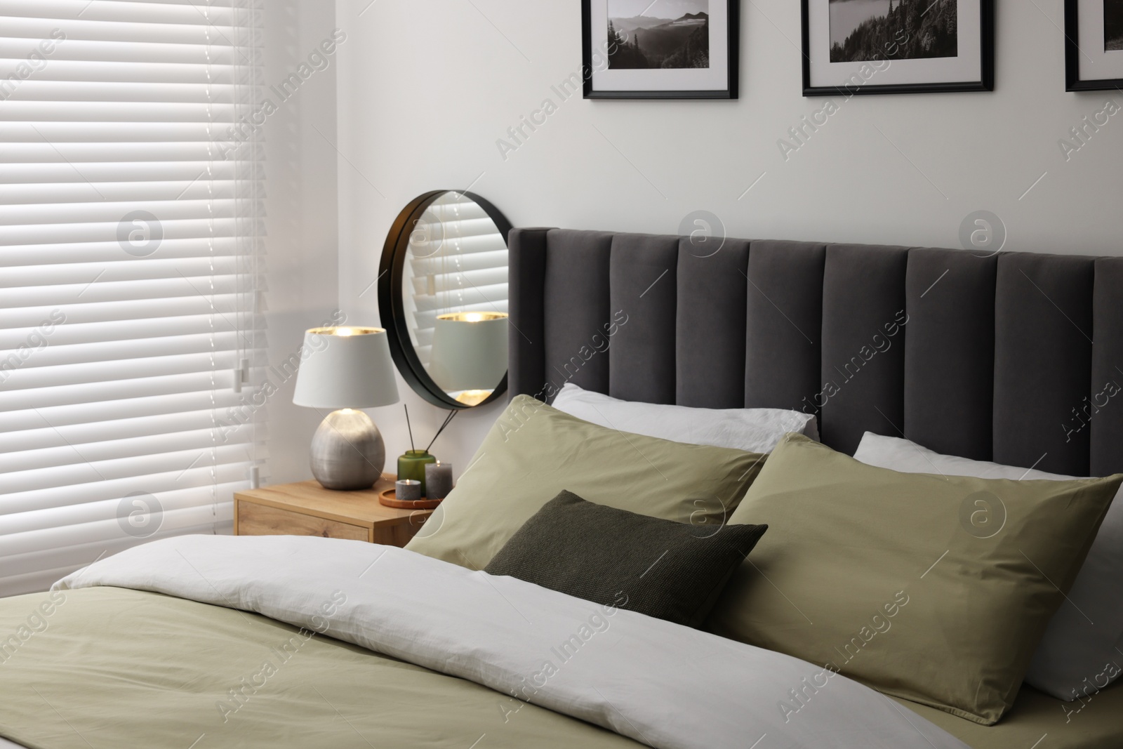 Photo of Window with horizontal blinds and comfortable bed in room