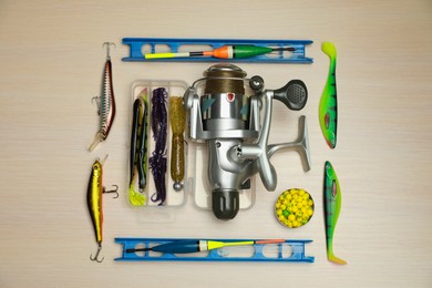 Photo of Different fishing equipment on light wooden table, flat lay