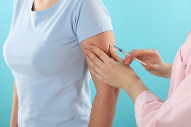 Photo of Diabetes. Woman getting insulin injection on light blue background, closeup