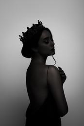 Image of Silhouette of woman wearing crown on light grey background