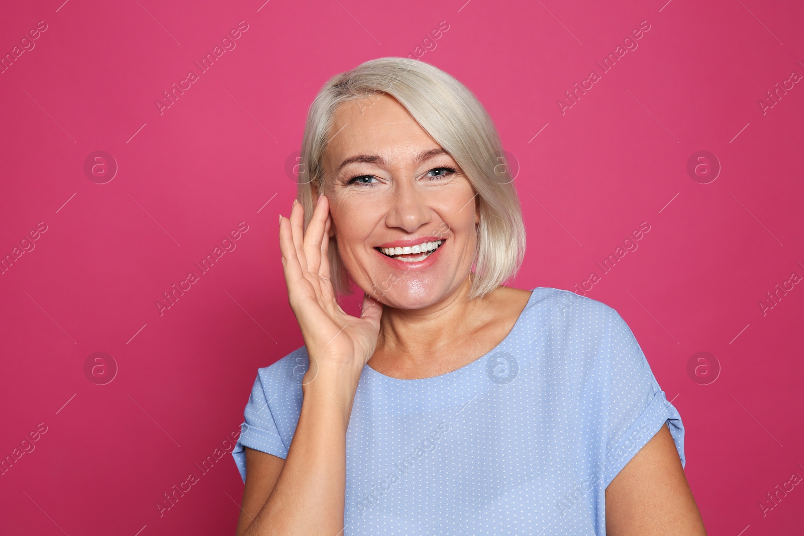 Photo of Portrait of mature woman laughing on color background