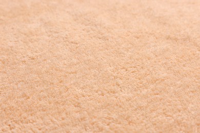 Photo of Soft pale orange towel as background, closeup