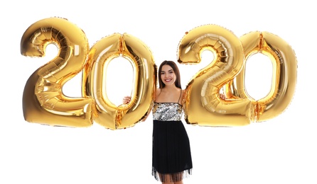 Photo of Happy young woman with golden 2020 balloons on white background. New Year celebration