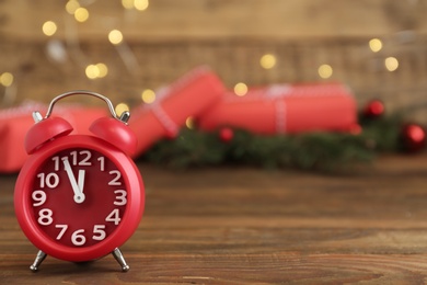 Alarm clock and Christmas gifts on wooden table, space for text. Boxing day