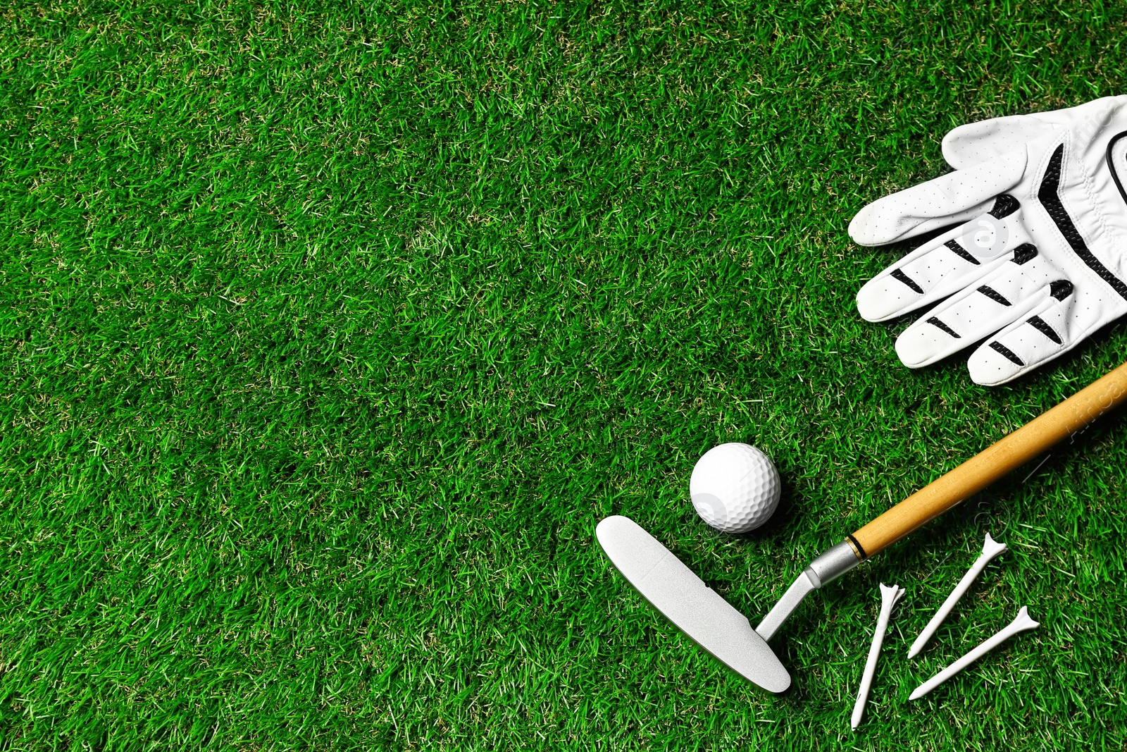 Photo of Flat lay composition with golf equipment on green course. Space for text