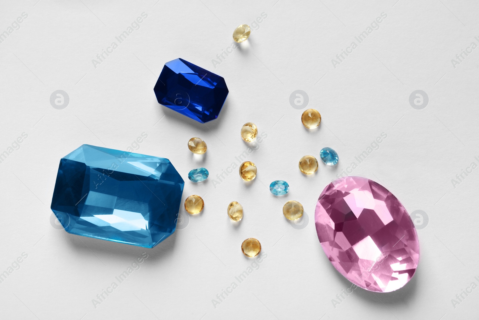 Photo of Different beautiful gemstones for jewelry on white background, flat lay