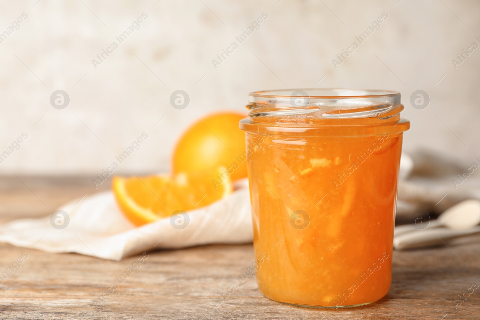 Photo of Homemade delicious orange jam on wooden table