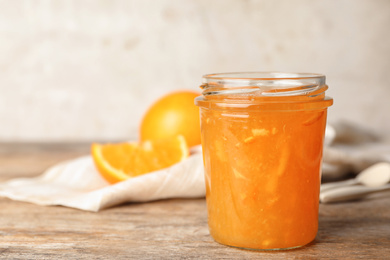 Photo of Homemade delicious orange jam on wooden table