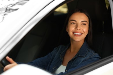 Photo of Enjoying trip. Happy young woman in car, view from outside