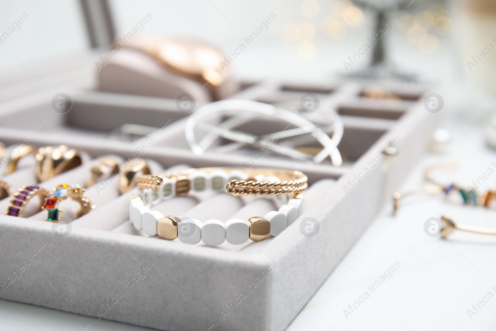 Photo of Elegant jewelry box with beautiful bijouterie on white table, closeup