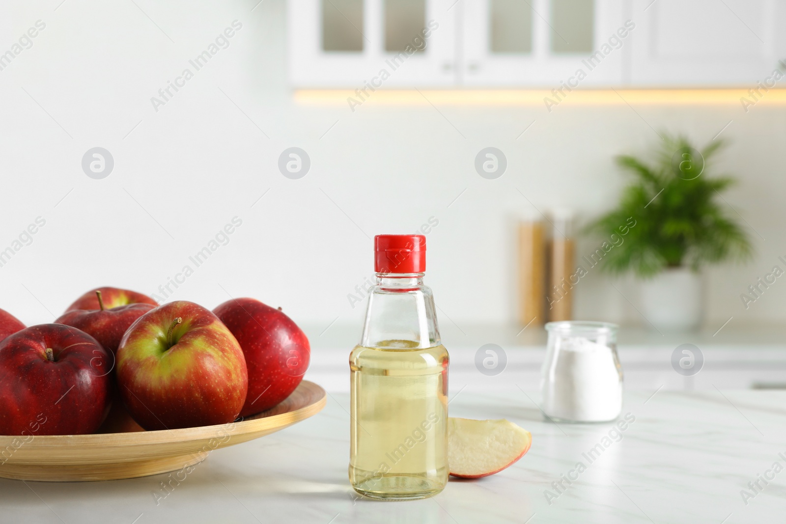 Photo of Apple vinegar and baking soda on white marble table in kitchen. Eco friendly natural detergents