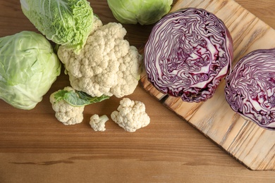 Photo of Flat lay composition with different cabbages on wooden background