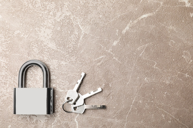 Photo of Steel padlock, keys and space for text on marble background, flat lay. Safety concept