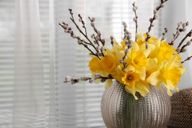 Photo of Bouquet of beautiful yellow daffodils and willow twigs near window. Space for text
