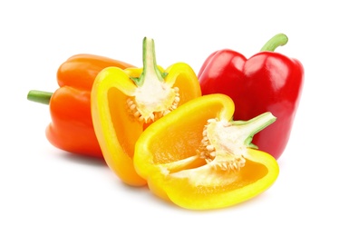 Whole and cut ripe bell peppers on white background