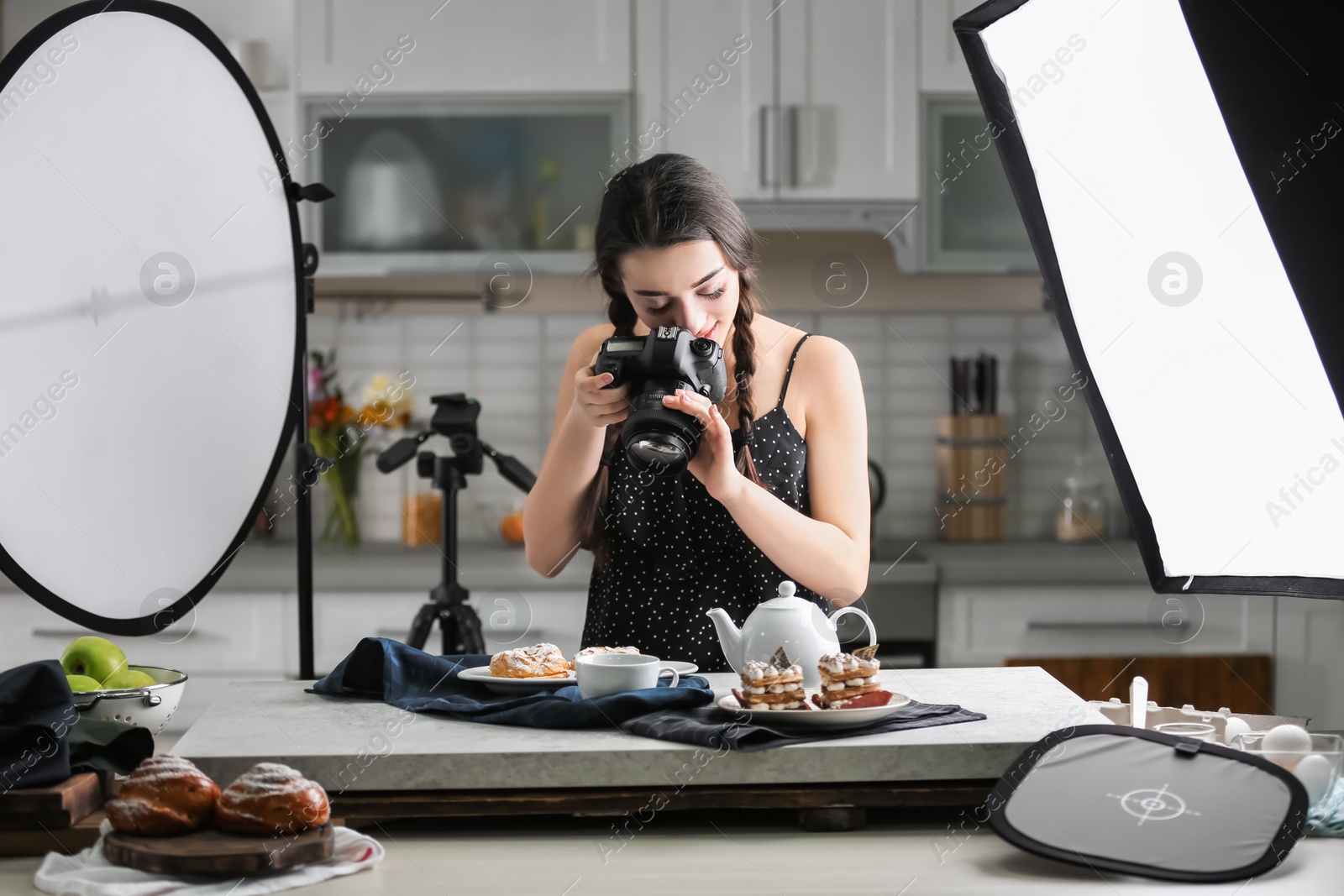 Photo of Young woman with professional camera taking food photo in studio