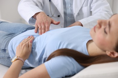 Photo of Gastroenterologist examining patient with stomach pain in clinic, closeup